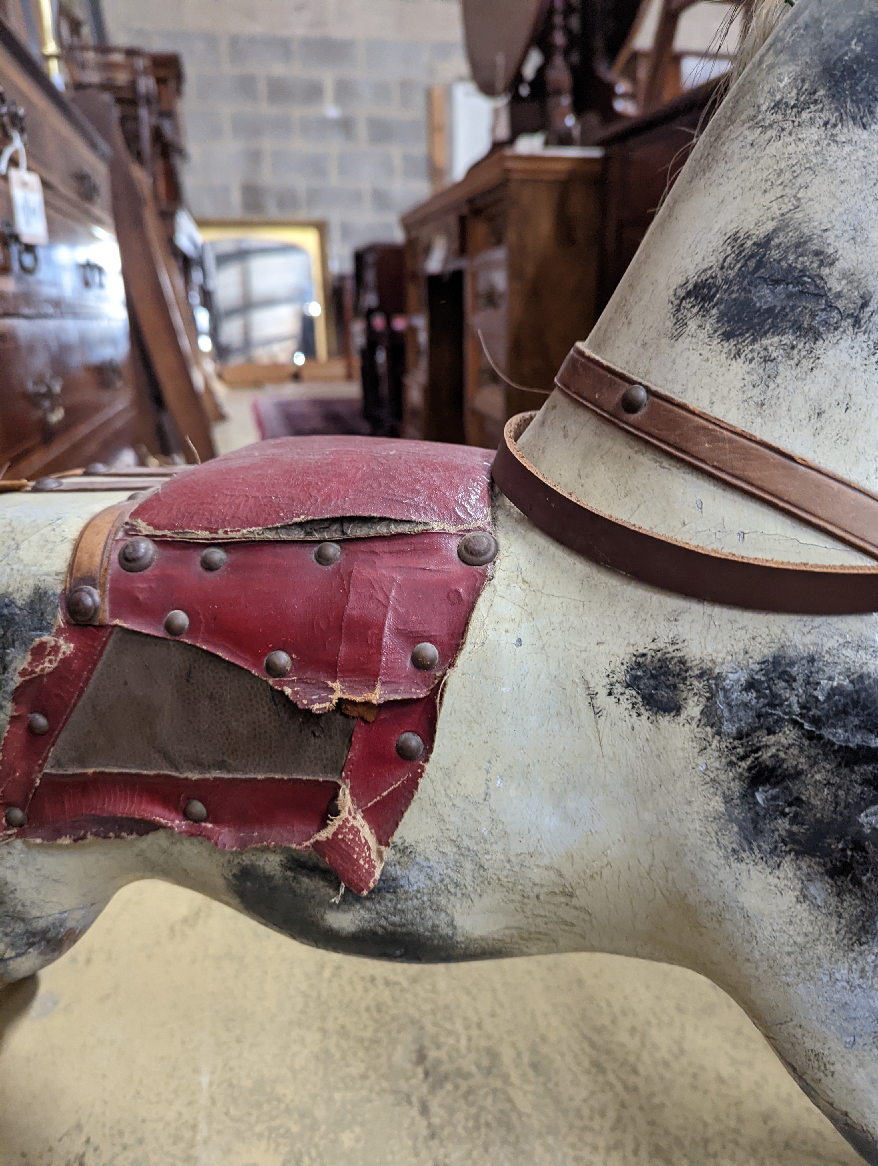 A Victorian carved and painted wood rocking horse, lacking underframe, length 77cm and two painted wood hobby horses, 58cm and 38cm